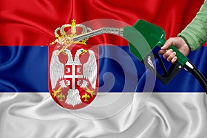 SERBIA flag Close-up shot on waving background texture with Fuel pump nozzle in hand. The concept of design solutions. 3d