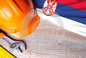 Serbia flag with different construction tools on wood background, with copy space for text