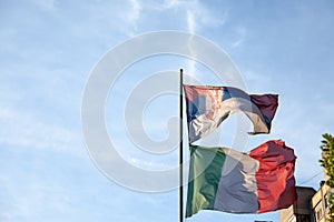 Flags of italy and Serbia waiving together at a pole in Serbia. photo