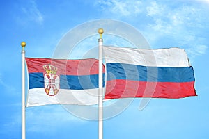 Serbia and Russia two flags on flagpoles and blue sky photo