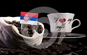 Serbian flag in a bag with coffee beans on black