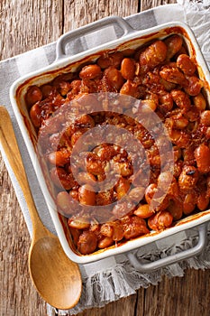 Serbian food: prebranac baked beans with onion close-up in baking dish. Vertical top view from above