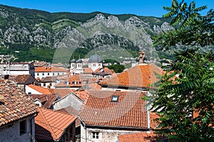 Red tiled roofs of old town houses in Kotor and Serbian Orthodox Church of St. Nikola , Montenegro
