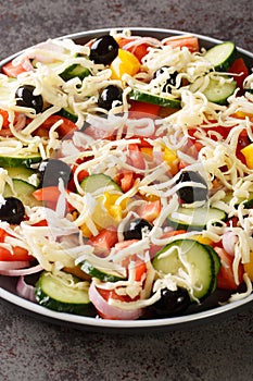 Serbian salad called sopska salata with vegetables and cheese closeup in the plate. Vertical