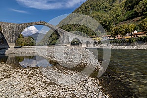 The Serchio River flows under the ancient Ponte della Maddalena, Borgo a Mozzano, Lucca, Italy