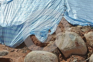 The plastic sheet is spread over the surface of the slope to prevent erosion. photo