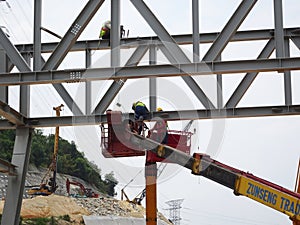 Construction workers using the mobile crane bucket