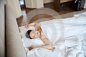 Serene adult woman dozing in her hotel room