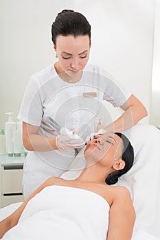 Serene asian woman taking procedure at spa