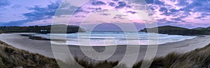 Serene beach panorama at Farr Bay, expansive sands meet calm sea under purple-pink sky