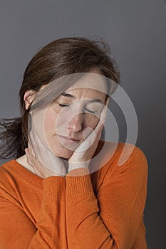 Serene beautiful middle aged woman enjoying a nap for wellbeing