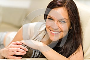 Serene cheerful woman lying on couch