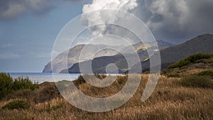 Serene Coastal Vista with Majestic Mountain Range and Skyline