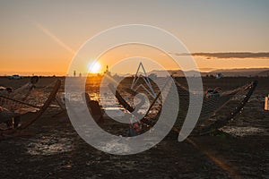 Serene desert sunset with geometric art installations at festival, remote location.