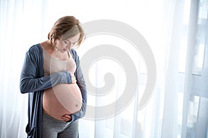 Serene expectant mother touching her tummy