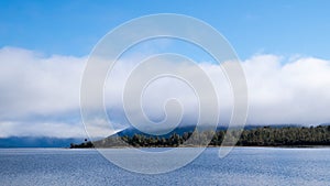 Serene landscape background of thick clouds above blue lake