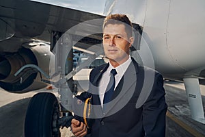 Serene licensed pilot standing by an aircraft