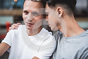 Serene male hugging glad comrade during communication