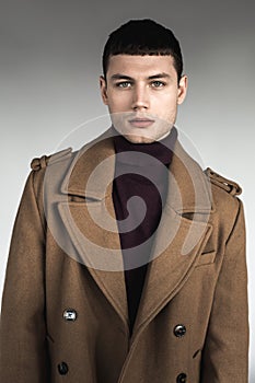 Serene male posing in stylish coat