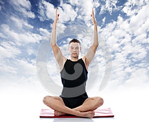 Serene man doing yoga exercise against the sky