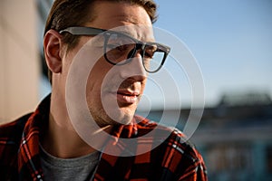 Serene man gazing and standing outside