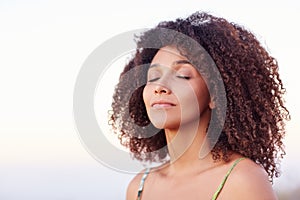 Serene mixed race woman with her eyes closed outdoors