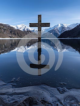 Serene mountain lake with wooden cross reflection photo