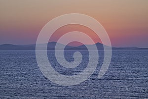 Serene Ocean Sunset with Distant Mountains