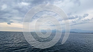 Serene Ocean View With Distant Mountains Under a Cloudy Sky at Dusk