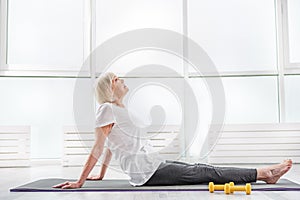 Serene old woman exercising in gym