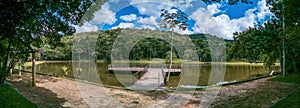 Serene panorama of Juiz de Fora botanical garden lake with wooden platform