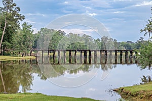 Serene and peaceful railroad track bridge over a public lake called Cherokee Lake, in Thomasville Georgia on a sunny day