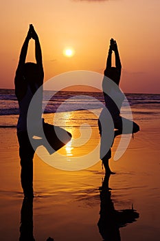 Serene People In The Beach Doing Yoga In The Sunset