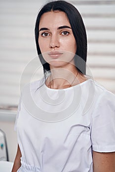 Serene pretty female cosmetologist working in office