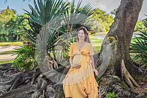 A serene and radiant pregnant woman after 40, surrounded by nature& x27;s beauty in the park, cherishing the journey of