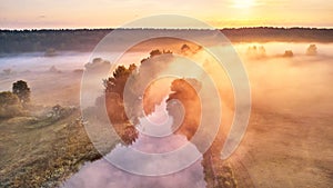 Serene river landscape with lush green trees and rising sun