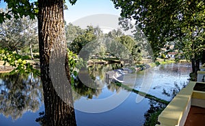 A serene river scene featuring a small stone dam with water gently cascading over the edge photo