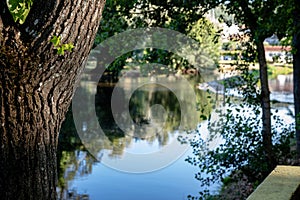 A serene river scene featuring a small stone dam with water gently cascading over the edge photo