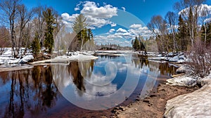 Serene River Scene with Melting Snow and Blue Sky Reflections