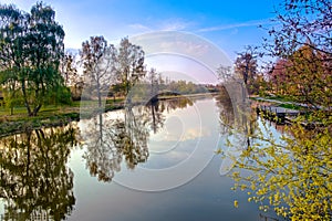 Tranquil river scene with trees reflected in water at sunset. photo