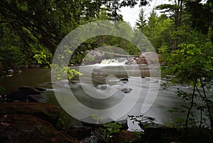 Serene Scenic Pike River Waterfall Through Large Granite Boulders Amberg Wisconsin with Large Open Water Area