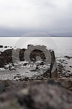 Serene seascape featuring a tranquil body of water with a cluster of jagged rocks.