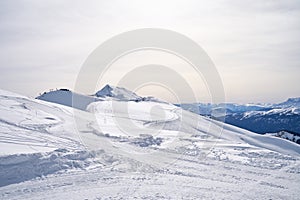 Serene snow-covered mountain landscape under a soft sky.