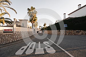 A serene suburban street lined with palm trees features a house for sale, evoking the prospect of a new beginning in a
