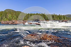 A serene summer view of the Namsen River in Namsskogan, Trondelag, Norway, showcasing a fast-flowing cascade
