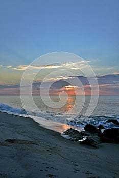 Serene Sunrise Over Rock Jetty on Beach