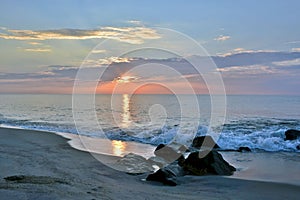 Serene Sunrise Over Rock Jetty on Beach