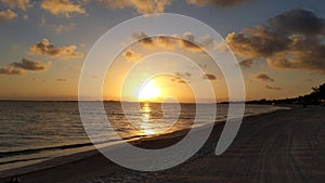 Serene Sunset Beach with Golden Reflections and Distant Shoreline