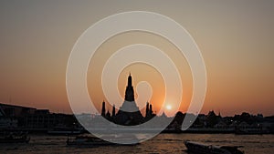 serene sunset behind Wat Arun, also known as the Temple of Dawn, located on the west bank of the Chao Phraya River in