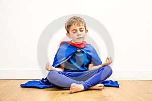 Serene superhero boy meditating with zen yoga, relaxation and mindfulness